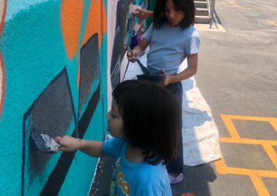 Image of a mural being painted by participants during the Yorkdale Elementary Mural Project.