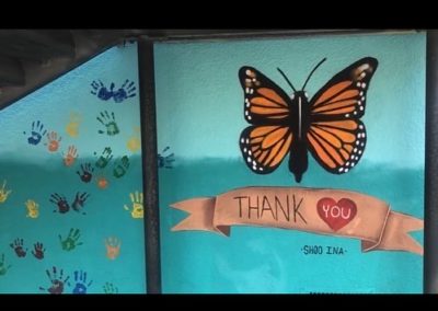 Image of a mural made during the Yorkdale Elementary Mural Project. The image shows a monarch butterfly and a thank you banner with a heart underneath.