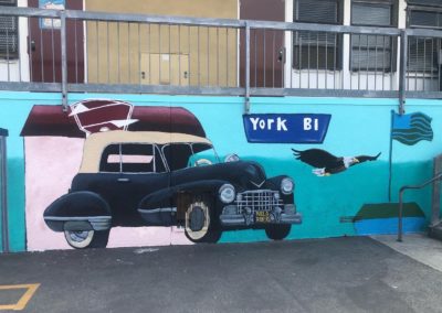 Image of a mural made during the Yorkdale Elementary Mural Project. The image shows a black car with a York Bl street sign, as well as a bald eagle.